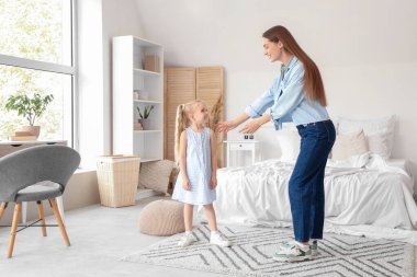 Yatak odasında dans eden küçük tatlı bir kızla dadı.