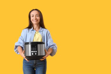 Sarı arka planda çoklu tenceresi olan güzel bir kadın.