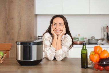 Mutfaktaki masada çoklu ocağı olan güzel bir kadın.