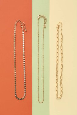 Renkli arka planda zarif altın zincirler