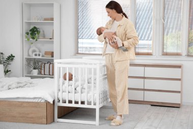 Mutlu annenin kucağında uyuyan tatlı bir bebek var.