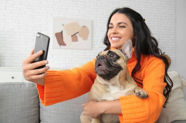 Fransız bulldoglu güzel bir kadın evde selfie çekiyor.