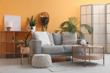 Masalı gri kanepe, katlanır ekran ve modern oturma odasının iç kısımlarında bitkiler.