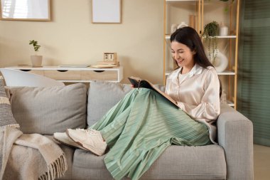 Evinde İncil okuyan güzel genç bir kadın.