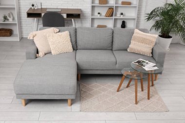 Oturma odasının iç tarafında rahat bir kanepe ve cam sehpa.