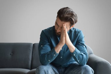 Sakallı adam evde dua ediyor.