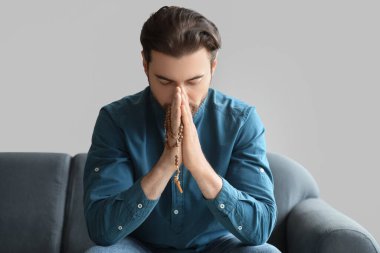 Sakallı adam evde dua ediyor.