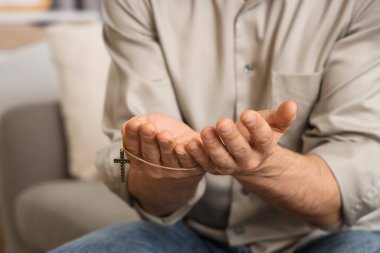 Evde dua eden dindar bir adam, yakın plan.