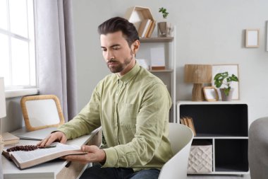 Evde İncil okuyan dindar adam