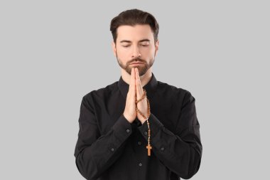 Gri arka planda dua eden dindar adam