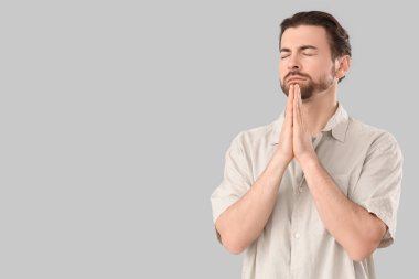 Gri arka planda dua eden dindar adam