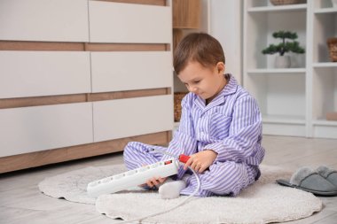 Uzatma kablosu olan şirin bir çocuk evde oturuyor. Çocuk tehlikede.