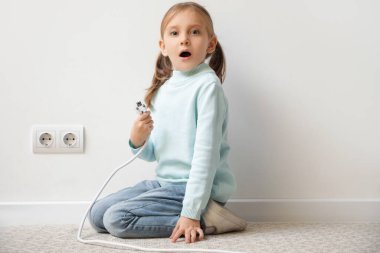 Evde prizin yanında küçük bir kız şok oldu. Çocuk tehlikede.