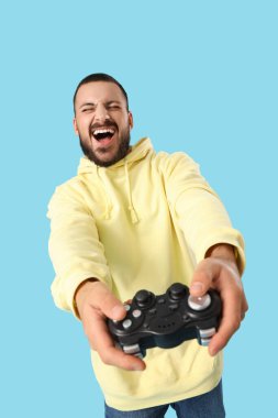 Mavi arka planda oyun evi olan mutlu genç adam