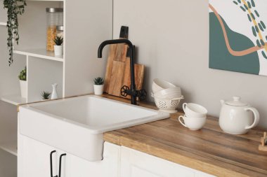 Mutfakta mutfak tezgahı ve lavabo beyaz duvarın yanında.