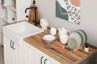 Mutfak tezgahının yanında lavabo ve çatal bıçak var.