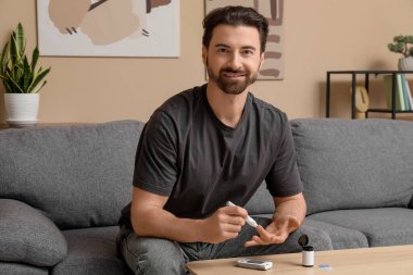 Şeker hastası adam evde tükenmez kalem kullanıyor.