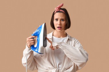 Bej arka planda demire dokunan genç kadın