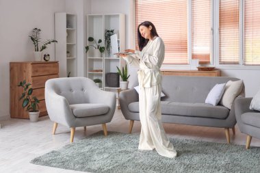 Evde dizüstü bilgisayarla çalışan rahat pijamalı serbest bir kadın.