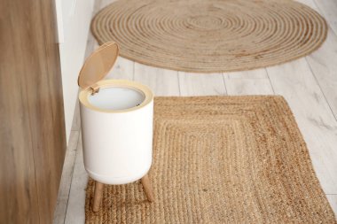 Mutfakta halının üzerindeki çöp tenekesi.