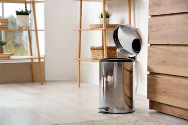 Oturma odasında ayak pedalı olan çöp kutusu.