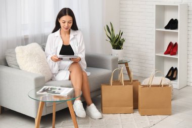 Giyim mağazasında dergi okuyan güzel bir kadın.