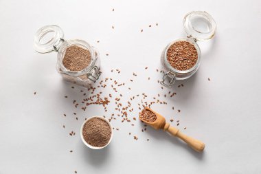 Keten tohumlu kavanoz ve gri arka planda bir kase un.