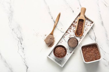 Keten tohumları ve beyaz zemin üzerinde un olan tahta kaşık.