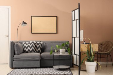 Oturma odasının içinde, kanepe sehpası ve katlanır ekran var.