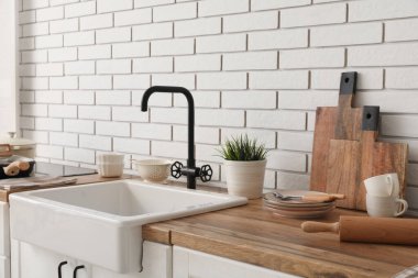 Seramik lavabosu ve mutfakta tabakları olan ahşap tezgah. Yakın çekim.