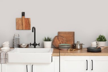 Seramik lavabo ahşap tezgahta ve mutfak aletleri. Yakın çekim.