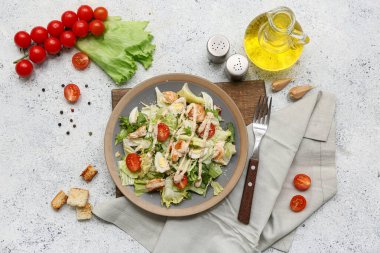 Lezzetli tavuklu Sezar salatası ve beyaz arka planda malzemeler.