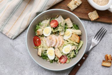 Gri arka planda lezzetli tavuklu Sezar salatası