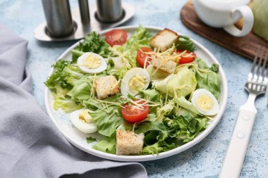 Mavi arka planda lezzetli Sezar salatası tabağı, yakın plan.