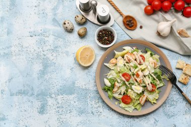 Lezzetli tavuklu Sezar salatası ve mavi arka planda farklı baharatlar.