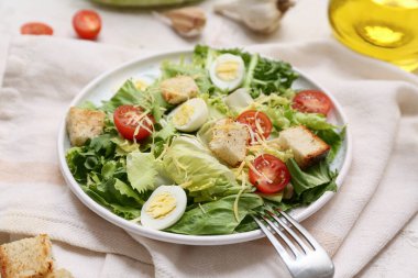 Beyaz arka planda lezzetli Sezar salatası tabağı, yakın plan.