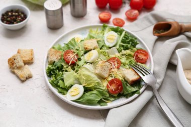 Lezzetli Sezar salatası ve beyaz arka planda bir kase biber, yakın plan.