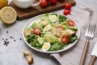 Lezzetli Sezar salatası, limon ve biberli gri arka plan.