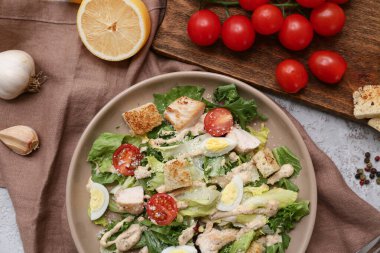Lezzetli tavuklu Sezar salatası, limon ve sarımsaklı gri arka plan, yakın plan.