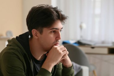 Depresyondaki genç adam evde, yakın çekim.