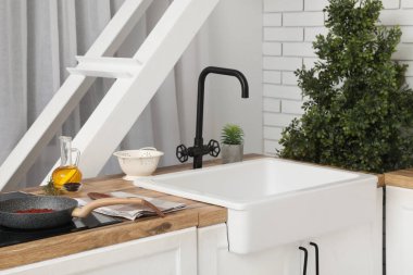 Lavabo ve çatal bıçak mutfak tezgahında, pencerenin yanında, yakın plan.