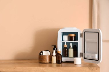 Odadaki bej duvarın yanındaki çekmecelerde kozmetik ürünleri olan küçük bir buzdolabı. Yakın çekim.