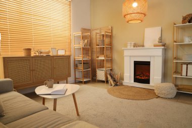 İçinde şömine, kanepe ve raf üniteleri olan rahat bir oturma odası.