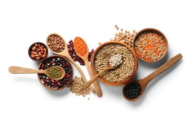 Tahta kaseler ve kaşıklar beyaz arka planda farklı baklagillerle