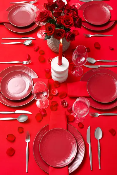 Sevgililer Günü kutlaması için yemek masası, mumlar ve kırmızı güller.
