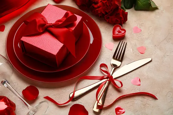 Sevgililer Günü için güzel bir masa. Hediye kutusu ve bej rengi grunge arka planda kırmızı dekor.