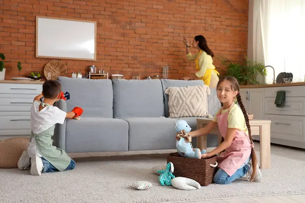 Evdeki temizlik işlerinde annelerine yardım eden sevimli çocuklar.