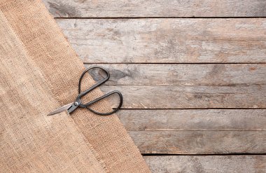Çuval bezi parçaları ve makas tahta zemin üzerinde