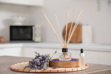 Mutfaktaki masada lavanta çiçekleri ve gerekli yağla Reed dağıtıcı, yakın plan.