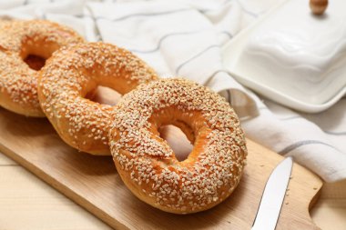 Tahta arka planda susam tohumlu lezzetli simit tahtası, yakın plan.